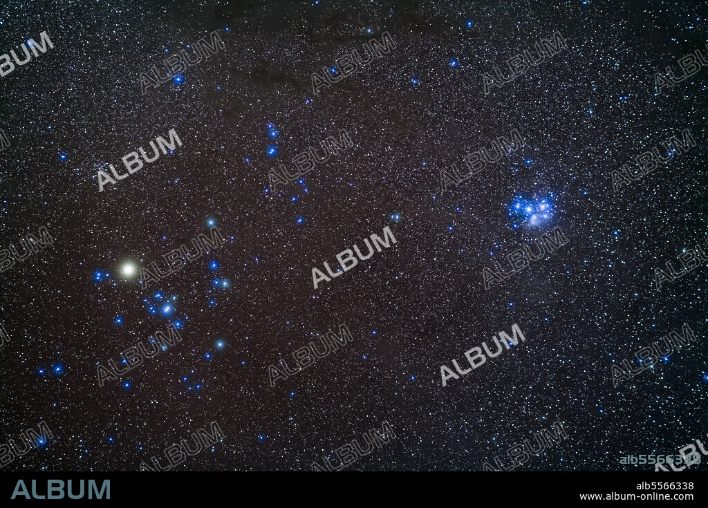 A portrait of the two groups of half-sisters related in mythology as daughters of Atlas: the Hyades, at left, and the blue Pleiades, at right, two nearby open star clusters in Taurus. The bright star is Aldebaran, the eye of Taurus.. This area of the sky is filled with dust which colours the sky in shades of brown and blue.