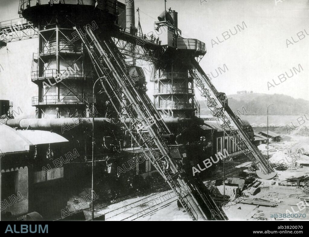 The Krupp family, a prominent 400 year old German dynasty from Essen, have become famous for their production of steel, artillery, ammunition, and other armaments. Friedrich Krupp built a pioneering steel foundry in Essen in 1810. His son Alfred invested heavily in new technology to become a significant manufacturer of steel rollers and railway tires. He also invested in the revolutionary Bessemer process and acquired many mines in Germany and France. The company began to make steel cannons in the 1840s. Low non-military demand and government subsidies meant that the company specialized more and more in weapons: by the late 1880s the manufacture of armaments represented around 50% of Krupp's total output. At the time Krupp's was the world's largest industrial company and the largest private company in the German empire. When Adolf Hitler came to power in Germany in 1933, the Krupp works became the center for German rearmament. The choices of the Krupp family and firm during the Nazi era, including support of Hitler and use of forced labour, are part of the legacy. No photographer credited, undated.