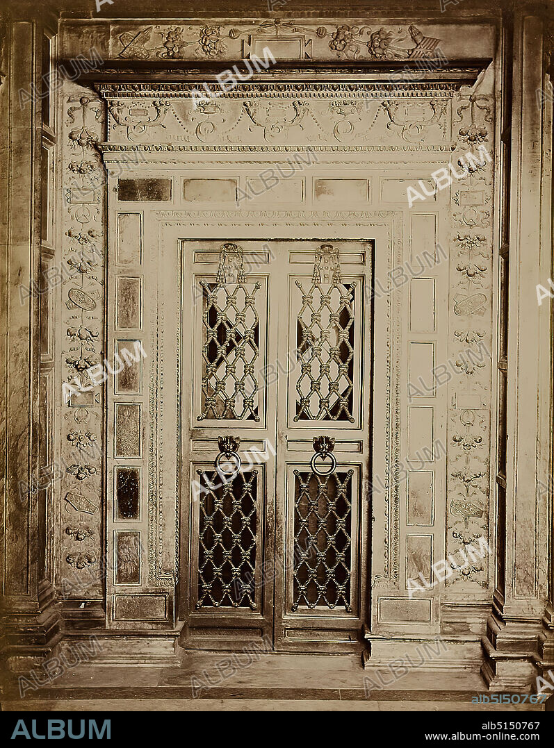Paolo Lombardi, The entrance to the library in Siena Cathedral, albumin paper, black and white positive process, sheet size: height: 26.00 cm; width: 20.40 cm, stamp engraving: recto and left: blind stamp: P. Lombardi, Fotografo, Siena, inscribed: recto on the cardboard: Siena, architectural photography, church interior, sculpture, sculpture, sculpture art, door frieze, door beam, door jamb, portal/edicula.