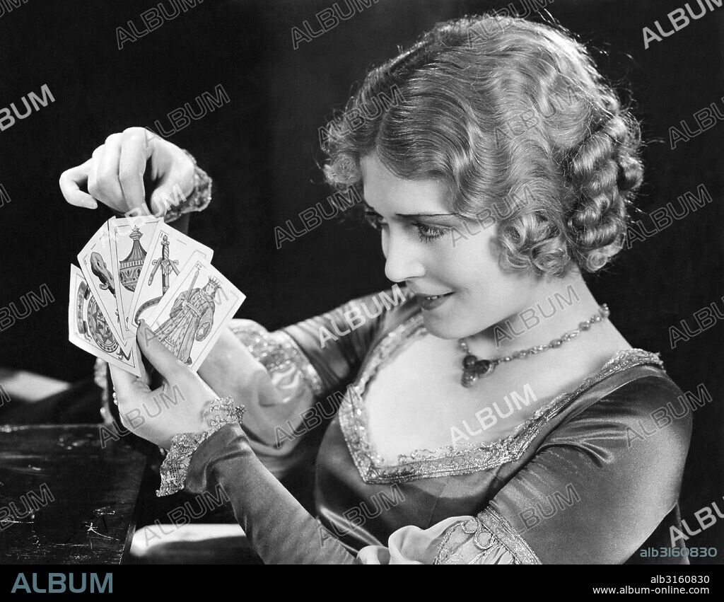 Hollywood, California: c. 1926 Actress Vilma Banky looks at a hand of tarot cards.