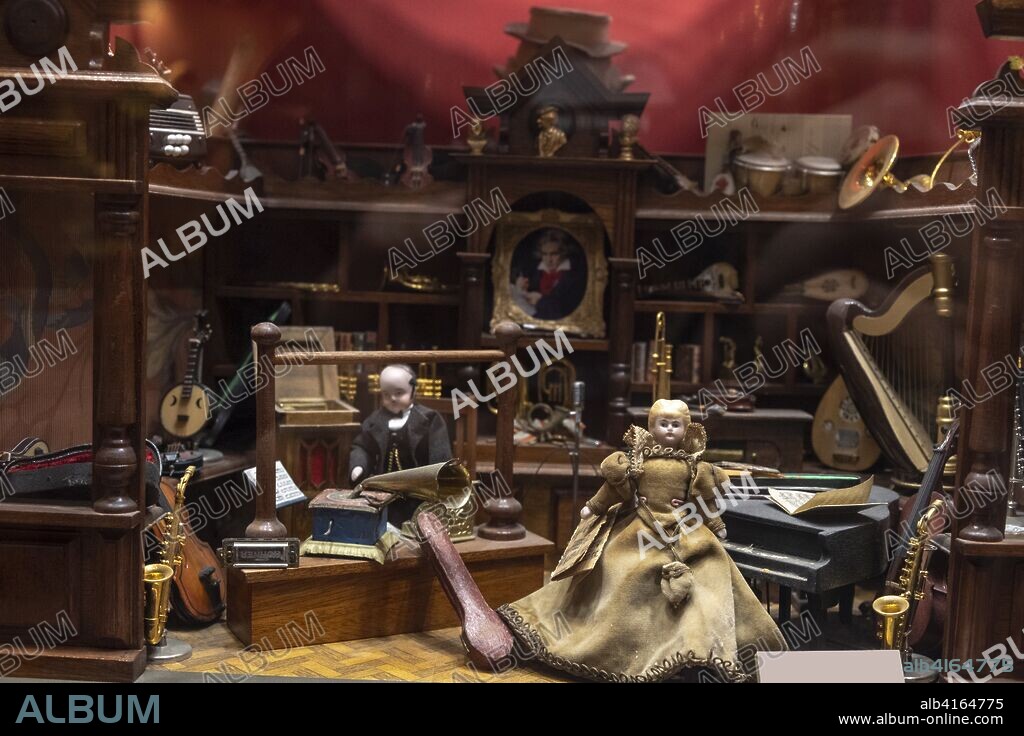 Vintage Dollhouse the music room with a piano, a trumpet, two dolls and many instruments.