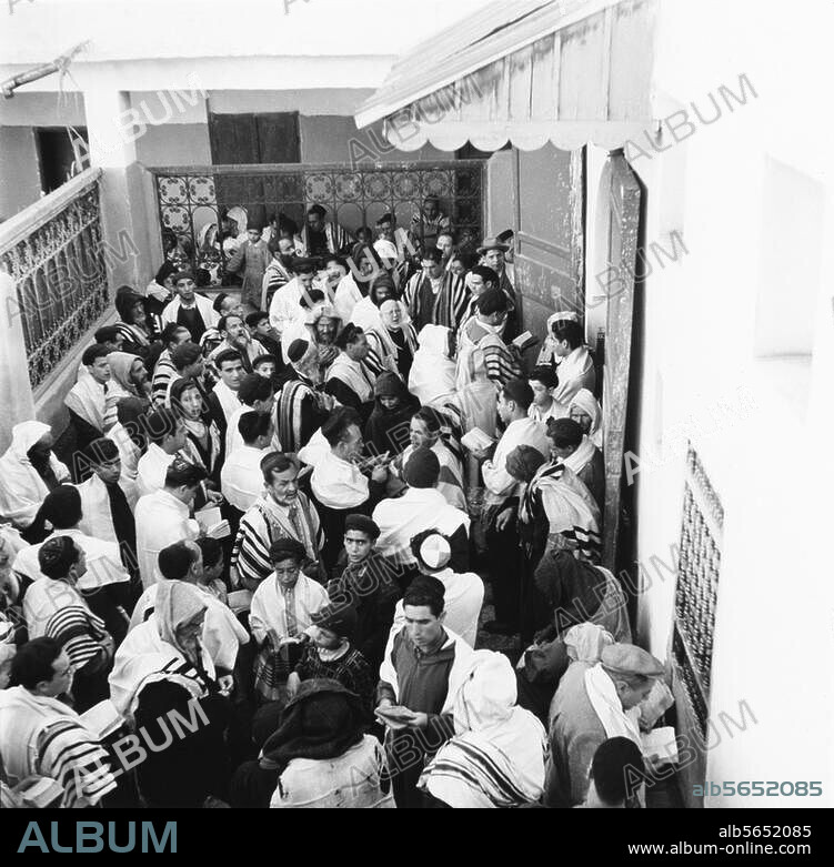 Ethnologie / Juifs. - Quartier juif à Marrakech (Maroc) :. des hommes priant dans la cour de la synagogue. Photo, 1952.
