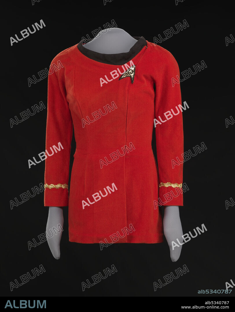 Starfleet uniform worn by African-American actor Nichelle Nichols (born 1932) as the character Lt. Uhura on the television show Star Trek. The kiss scene between  Uhura and Captain Kirk, played by William Shatner, in "Plato's Stepchildren" (season 3 episode 10 of Star Trek: The Original Series, first broadcast in 1968), is popularly cited as the first example of a scripted interracial kiss on United States television. Mini-dress made from synthetic velour fabric with gold braid details and a black knit collar. The dress has full-length fitted sleeves, with a band of gold braid sewn around each sleeve approximately three (3) inches above the cuff hem. The dress closes with a metal invisible zipper that begins below the proper left front waist and ends at the proper left top shoulder, running across the front rather than at the side of the bodice.