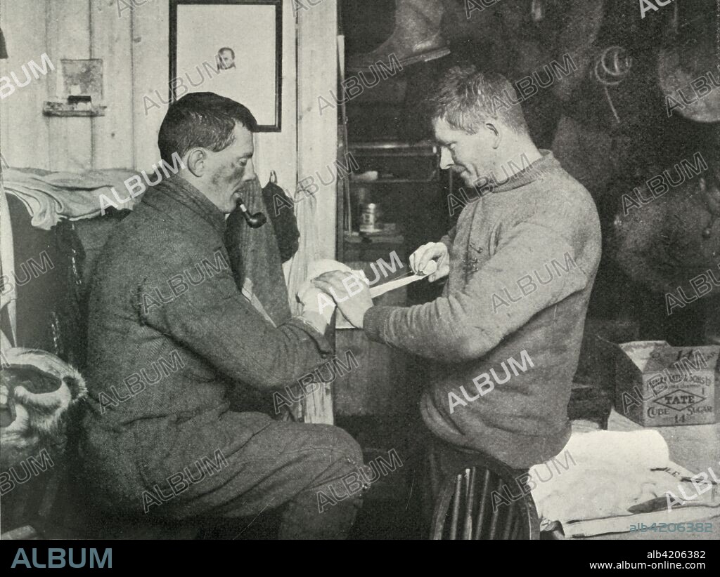 'Petty Officer Evans Binding Up Dr. Atkinson's Hand. The marks on Atkinson's face are frost-bites', 5 July 1911, (1913). Edgar Evans (1876-1912) bandaging the frostbite-affected hand of Dr Edward Atkinson (1881-1929). The final expedition of British Antarctic explorer Captain Robert Falcon Scott (1868-1912) left London on 1 June 1910 bound for the South Pole. The Terra Nova Expedition, officially the British Antarctic Expedition (1910-1913), included a geologist, a zoologist, a surgeon, a photographer, an engineer, a ski expert, a meteorologist and a physicist among others. Scott wished to continue the scientific work that he had begun when leading the Discovery Expedition to the Antarctic in 1901-04. He also wanted to be the first to reach the geographic South Pole. Scott, accompanied by Dr Edward Wilson, Captain Lawrence Oates, Lieutenant Henry Bowers and Petty Officer Edgar Evans, reached the Pole on 17 January 1912, only to find that the Norwegian expedition under Amundsen had beaten them to their objective by a month. Delayed by blizzards, and running out of supplies, Scott and the remainder of his team died at the end of March. Their bodies and diaries were found eight months later. From Scott's Last Expedition, Volume I. [Smith, Elder & Co., London, 1913].