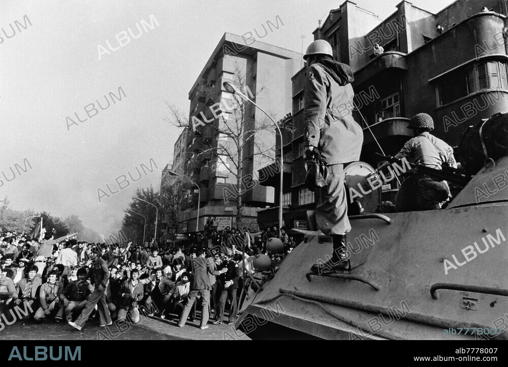 Manifestations massives à l'automne 1978 contre le régime du Shah Mohammed Reza Pahlevi. Au cours des émeutes les plus violentes depuis celles du "Vendredi noir" (8 septembre), près de 50 à 60 000 jeunes Iraniens, en particulier des étudiants et des lycéens, ont envahi les rues principales de Téhéran pendant près de 10 heures. Ils ont incendié de nombreux bâtiments publics, hôtels, banques, magasins et voitures. Des soldats à bord d'un véhicule blindé observent les manifestants. Photo, 5 novembre 1978.