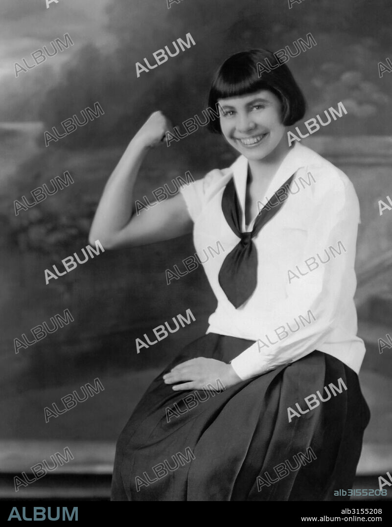 St. Louis, Missouri: 1923 Birdie Reeve, the world's fastest typist, can type over 200 words per minute. She views typing as a sport, and here displays her muscle development.