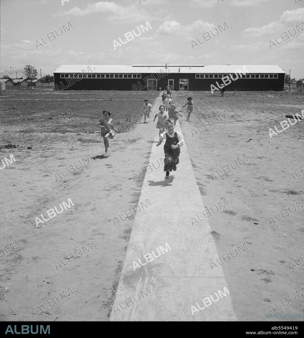 DOROTHEA LANGE. Farm Security Administration (FSA) camp at Farmersville. Nursery school children showing community laundry building. California.