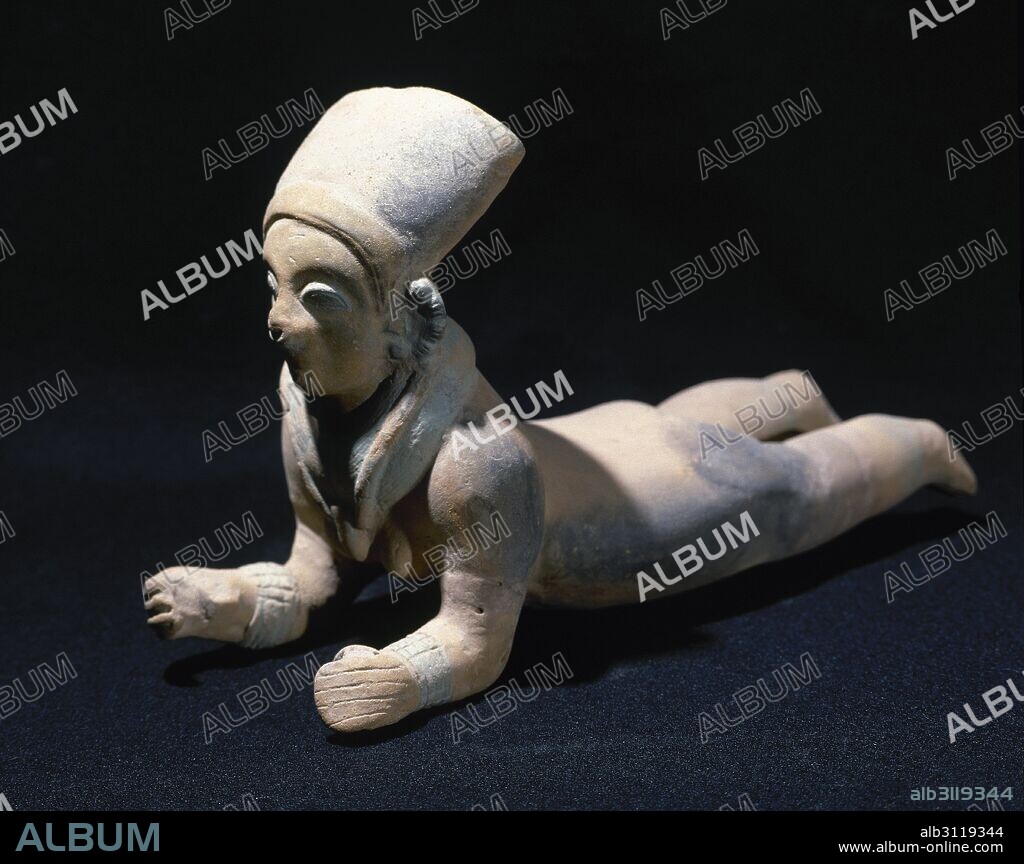 PERIODO PRECOLOMBINO-PREINCAICO. CULTURA JAMA-COAQUE (500 a. C. -500 d. C.). Localizada entre el cabo San Francisco y la actual Bahía de Caráguez. FIGURA DEL TIPO CHONE. Piezas vacías, realizadas a molde y a mano, con una decoración en cabeza y vestidos, llevando generalmente objetos rituales en las manos. PERSONAJE FEMENINO ESTIRADO, 28 x 18 cm. Procede del Ecuador. Colección particular.