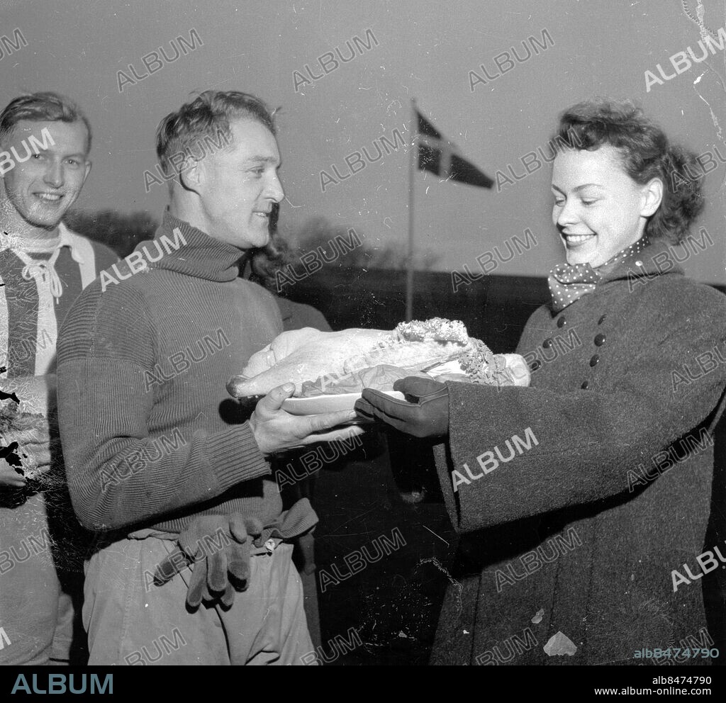 Göteborg november 1952. Gåsafotboll Gamla Ullevi - IFK Göteborg - gås utdelas till målvakten Henry Andersson och Bengt "Fölet" Berntsson av en av luciakandidaterna. Foto: Kamerareportage *** Local Caption *** GT Låda krep 2013-09 - påse november 1952. KAMERAREPORTAGE.