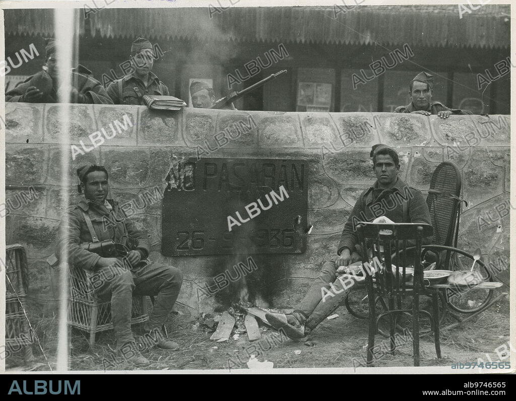 Madrid, 1939. Guerra Civil Española. Milicianos republicanos al lado de una placa propagandística en la que pone «No pasarán».