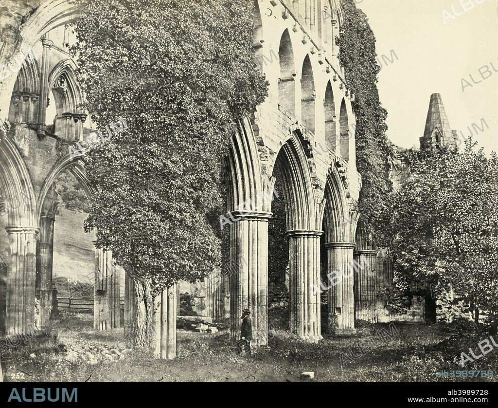 Rievaulx Abbey, North Yorkshire, 1850-1910. The ruins of Rievaulx Abbey, the first Cistercian abbey in the north of England, have been a tourist destination since the 18th century. In the Victorian era photographers were also drawn to record the picturesque, ivy-clad ruins. By 1917 these were in danger of collapse and Rievaulx Abbey was taken into the care of the Office of Works. Sir Charles Peers, Chief Inspector of Ancient Monuments, caused controversy by clearing the site of vegetation and establishing the principle of presenting historic monuments in neat, tidy, unobstructed settings. Albumen print.
