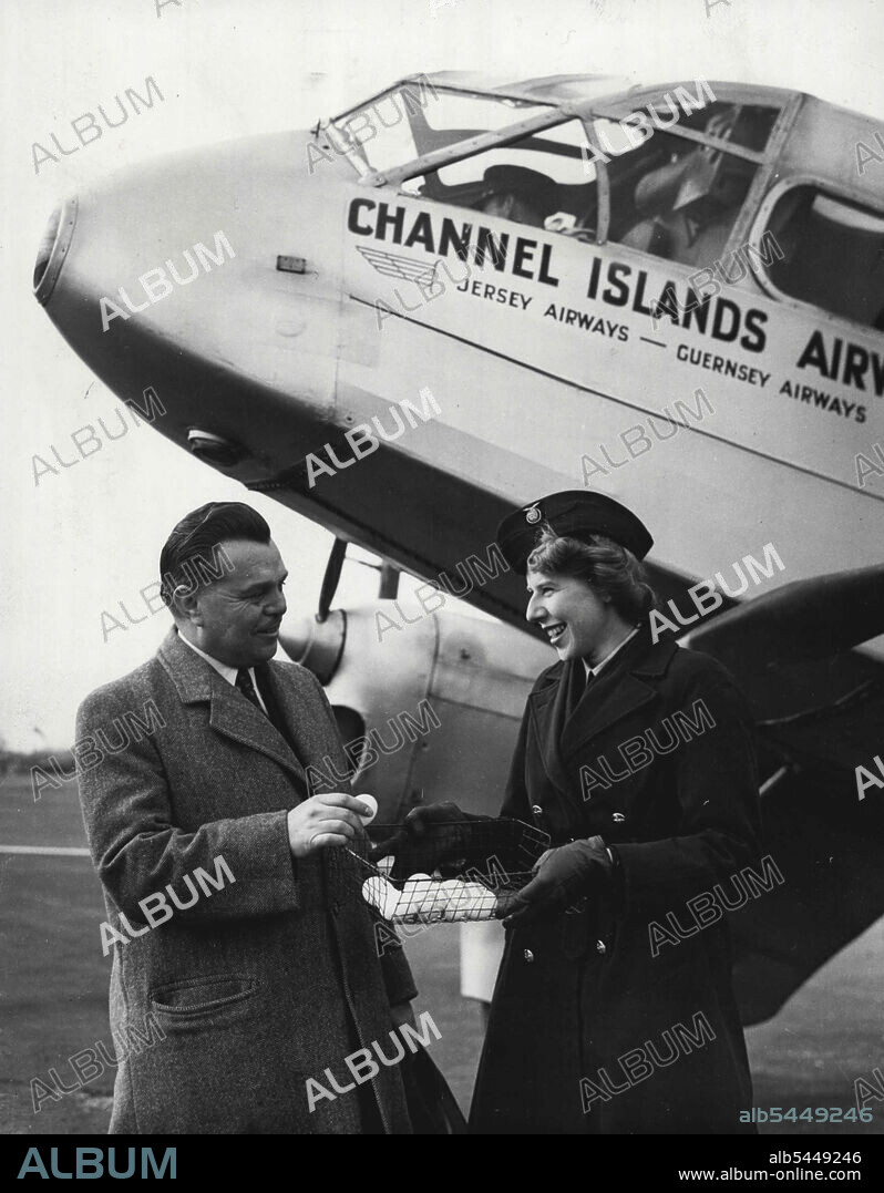 Eggs For 20,000th AIR Passenger. Picture shows: Julie Cook presenting the gift of eggs to Mr. Butlin at Croydon airport this afternoon (Tuesday). Mr Billy Butlinthe holiday camp king, arrived at Croydon by air from Jersey to-day to learn that he was the 20,000th passenger to be carried by **** the resumption of their service last year.  He was greeted by Air Hosters Julie Cook (ex-Wren) and presented with a gift of a dozen Jersy eggs. March 12, 1946.