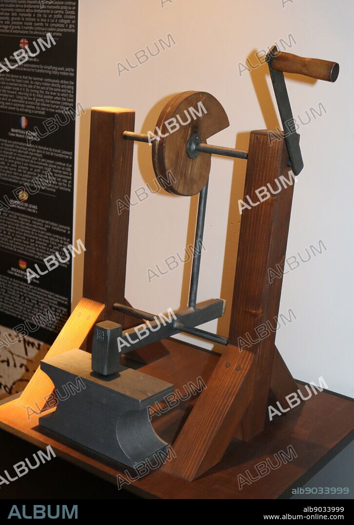 Re-construction of a Cam Hammer, from a drawing by Leonardo da Vinci, in the Madrid Codex I, folio 92 v. Leonardo applied a cam to this simple mechanical device for transforming rotary motion into intermittent motion. The energy that moves this device so that the hammer continuously strikes the anvil is derived directly from the hand crank, its rotary motion directly activating the cam: the hand crank is inserted into the side of the axis of the same and has a circular profile with a sudden break in it. By turning this, the lever to which the hammer is attached tilts forward, returning to its initial position when the hand crank has done a complete turn. Using the law of gravity, the hammer continues to fall heavily on the anvil; an automation process that relieves human fatigue. After having been long used in automatic meshes, the cam is now widely used in car engines, which deliver power by activating a camshaft.. Leonardo da Vinci (1452-1519), Italian artist and polymath.