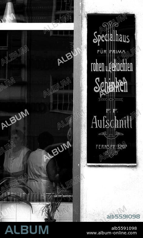 Handwerk und Gewerbe:. Fleischer. Schaufenster und altes Werbeschild einer Fleischerei in Wittenberg, Collegienstraße (Sachsen-Anhalt). Foto, 1990.