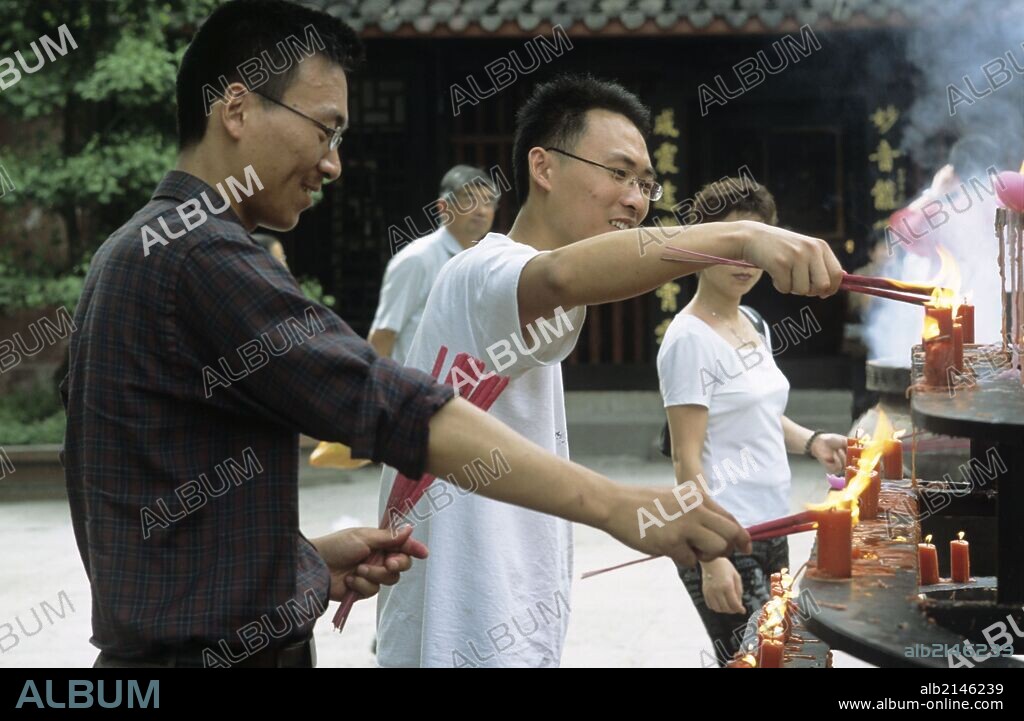 Two young men lighting incense at a Buddhist temple - Wenshu Temple - Chengdu - Sichuan Province, China (Photo by: Sovfoto/UIG via Getty Images).