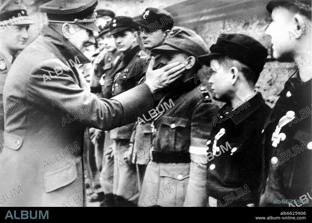 One of the last pictures of Adolf Hitler (taken on the 20th of March in 1945) shows him decorating members of the Hitler Youth in Berlin, which were put together as peoples' storm units (Volkssturm). 20/03/1945