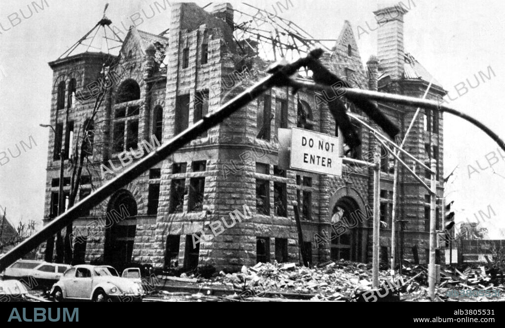 The 1974 Super Outbreak spawned 148 tornadoes, the largest number of tornadoes ever produced by one storm system. Thirty of these tornadoes were classified as F4 or F5 on the Fujita-Pearson Scale. There were 148 tornadoes confirmed in 13 US states, including Illinois, Indiana, Michigan, Ohio, Kentucky, Tennessee, Alabama, Mississippi, Georgia, North Carolina, Virginia, West Virginia, and New York. It extensively damaged approximately 900 square miles along a total combined path length of 2,600 miles. The Super Outbreak of 1974 remains one of the most outstanding severe convective weather episodes of record in the continental United States. Photo originally captioned: "This corner of the building once contained a clock tower, the once official time keeper of Monticello for many years. Courtesy of the Monticello Herald Journal.".