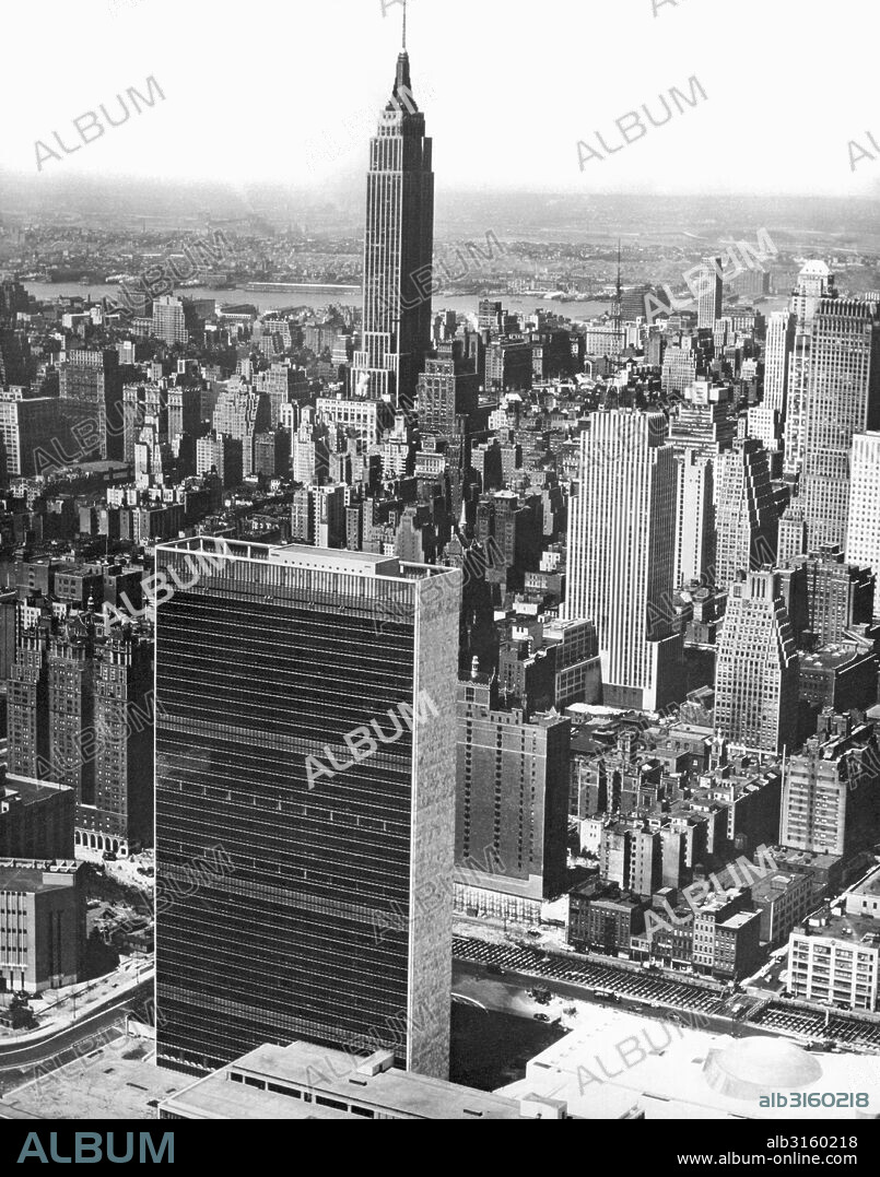 New York, New York: c. 1953 The United Nations Building highlights the spectacular skyline of mid-town Manhattan, with the Empire State Building rising in the background.