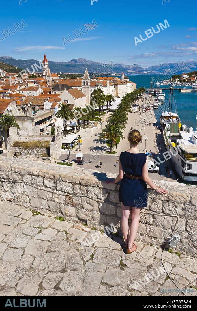 Tourist admiring the view from Kamerlengo Fortress over Trogir waterfront, Trogir, UNESCO World Heritage Site, Dalmatian Coast, Adriatic, Croatia, Europe.