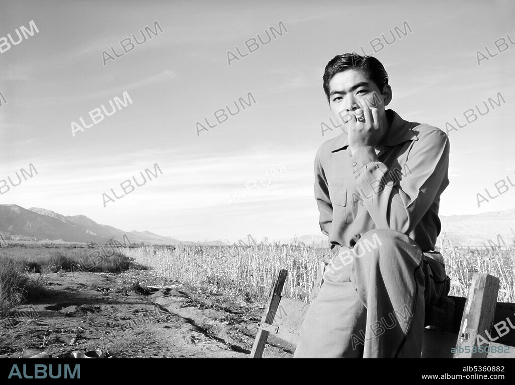 Tom Kobayashi, seated Portrait in Field, Manzanar Relocation Center, California, USA, Ansel Adams, Manzanar War Relocation Center Collection, 1943.