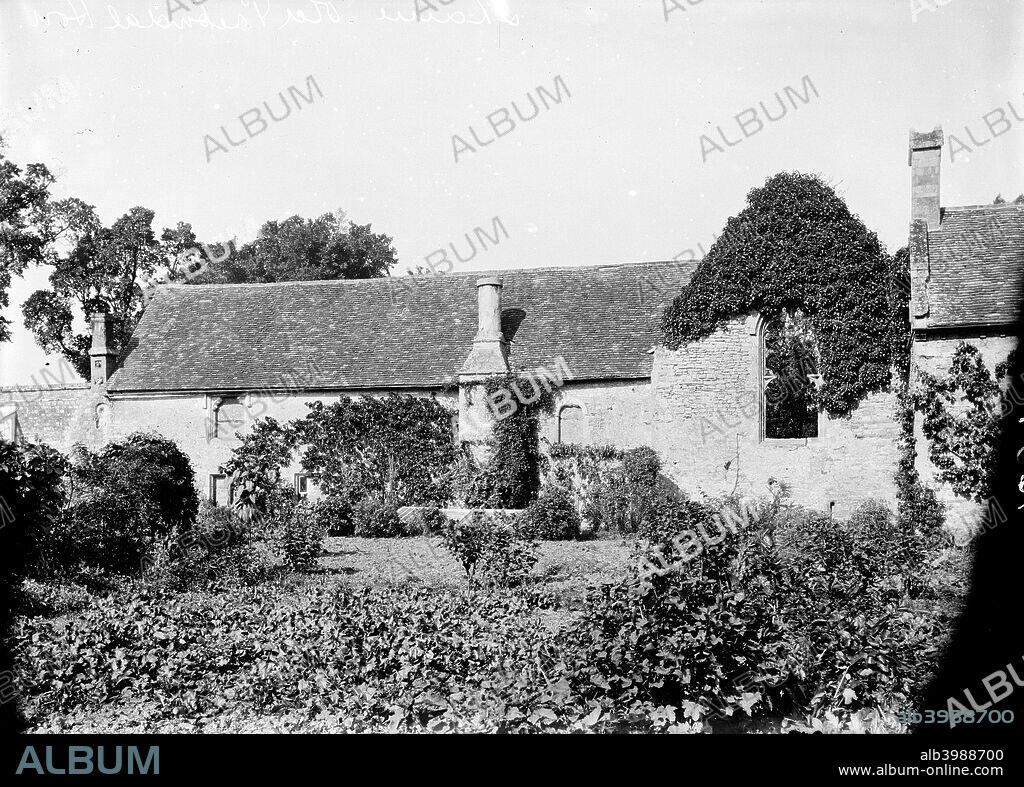 Prebendal House, Thame, Oxfordshire, c1860-c1922. The exterior of the long two storey range and the chapel, separated by a ruined wall with a traceried window. The house, first recorded in 1234, was built by Bishop Grosetete and parts are still occupied today.