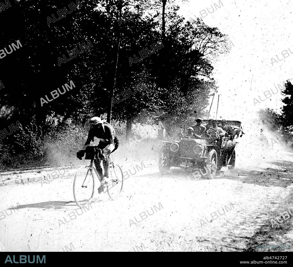Francois FABER (DEBUT 20 S.), le futur vainqueur du Tour de France de 1909, suivi de la voiture suiveuse Alcyon, de sa marque. Photographie d'amateur. Credit : Jean Vigne/KHARBINE-TAPABOR.