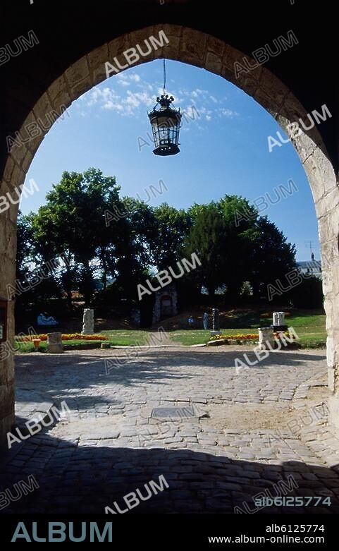 Dourdan (Dép.Essonne, Ile de France, Frankreich), Burg / Château (erbaut um 1220/1222 unter König Philipp II. August; von 1690 bis 1852 Gefängnis).-Blick aus dem Torhaus in den Innenhof mit Skulpturngarten.-Foto, undatiert.