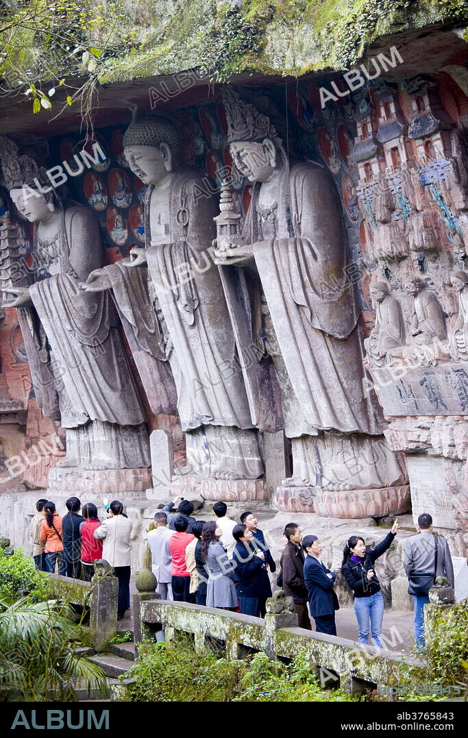 Tourists at Dazu rock carvings of Buddha of Great Sunlight, Buddha of Mercy at Mount Baoding, China.