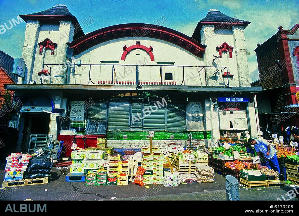 SIMON INGLIS. Temperance Billiard Hall, Cheetham Hill Road, Cheetham, Manchester, 2004. The front elevation of the former Temperance Billiard Hall on Cheetham Hill Road, Cheetham. The billiard hall was built in 1906 for the Temperance Billiard Halls Company, designed by in-house architect Norman Evans. It is Grade II Listed. The building later became known as the Hot Shots Snooker Club, and in the 21st century was in use as a fruit and vegetable warehouse and shop.