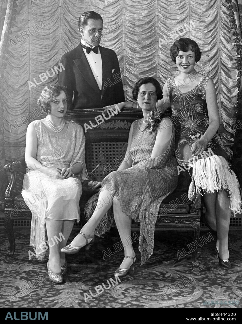 Orig. bildtext... FILM WORLD SHOW THEIR STUFF AT ANNUAL MOVIE BALL. The annual movie ball at Hotel Astor, New York City, just dazzled with colors and a fortune in style and gems. Photo taken at ball shows left to right, Mrs Niles Welch, wife of stage star, Rita Weiman, writer, Lois Wilson, actress and standing, Niels Welch, actor. 10-31-26. Anm. N Welch, 1888-1976, amerikansk skådespelare. Verksam i en rad stumfilmer och tidiga talfilmer 1910-1930-tal. D Welch, tidigare Dell Boone, skådespelare, gift med N Welch. R Weiman, 1885-1954, manusförfattare. L Wilson, 1894-1988, skådespelare. Klänningar Festkläder Foto: P & A Photos / AB text & Bilder / SVT / kod:5600 Mapp VEK-VELK sv/v kopia persons: DELL WELCH;LOIS WILSON;NILES WELCH;RITA WEIMAN sites: USA;NEW YORK.
