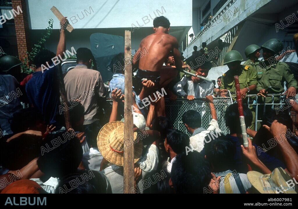 CAMBODIA Phnom Pehn Anti Khmer Rouge demonstration outside their city headquarters. Angry crowd at a fence armed by soldiers.