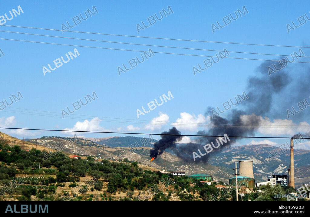 Humo producido por las chimeneas de la refinería de petroleo de Ballsh junto a la chimenea de la central térmica cerrada en la actualidad. República de Albania.