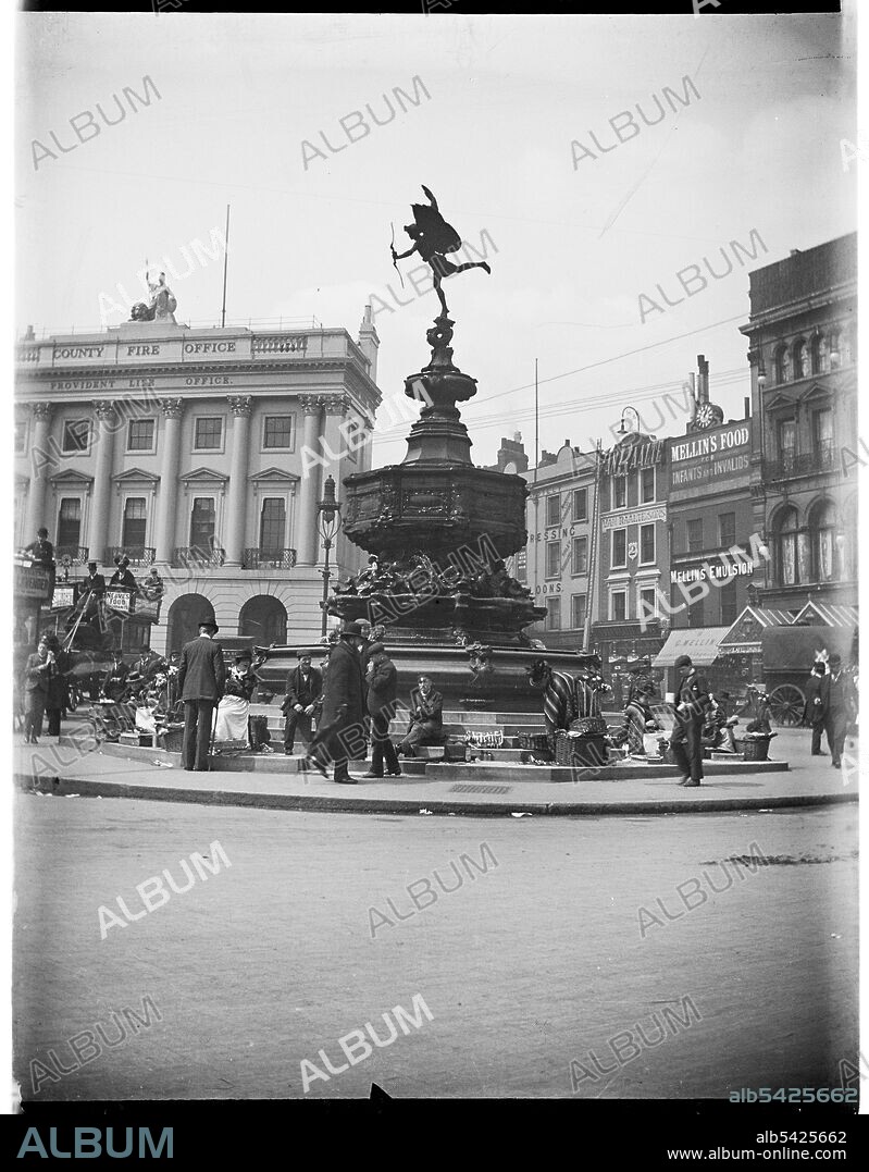 Shaftesbury Memorial Fountain, Piccadilly Circus, City of Westminster, Greater London Authority, 1895-1905. A view of Piccadilly Circus from the south-east showing street vendors seated around the Shaftesbury Memorial Fountain (also known as Eros). This photograph appears to have been taken sometime between 1895-1905 and therefore it seems unlikely that the photograph was taken by Charles William Prickett who was born in 1896. The photographs in the rest of his collection were taken between 1920-1940.