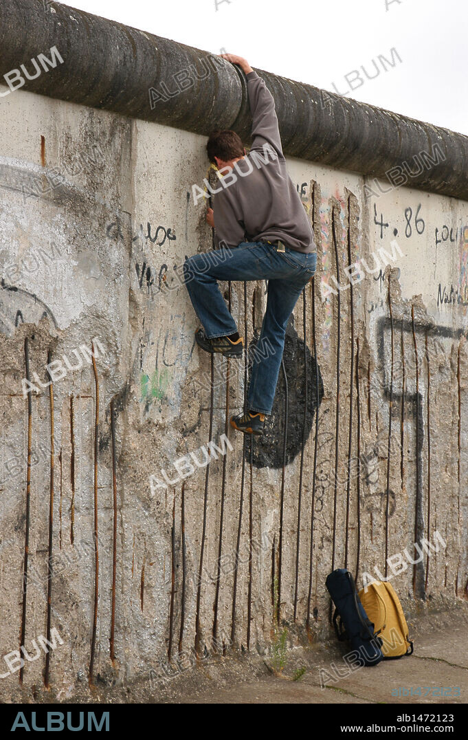 Joven trepando por el MURO DE BERLIN en Bernauerstrasse. S. XX. Berlín. Alemania.