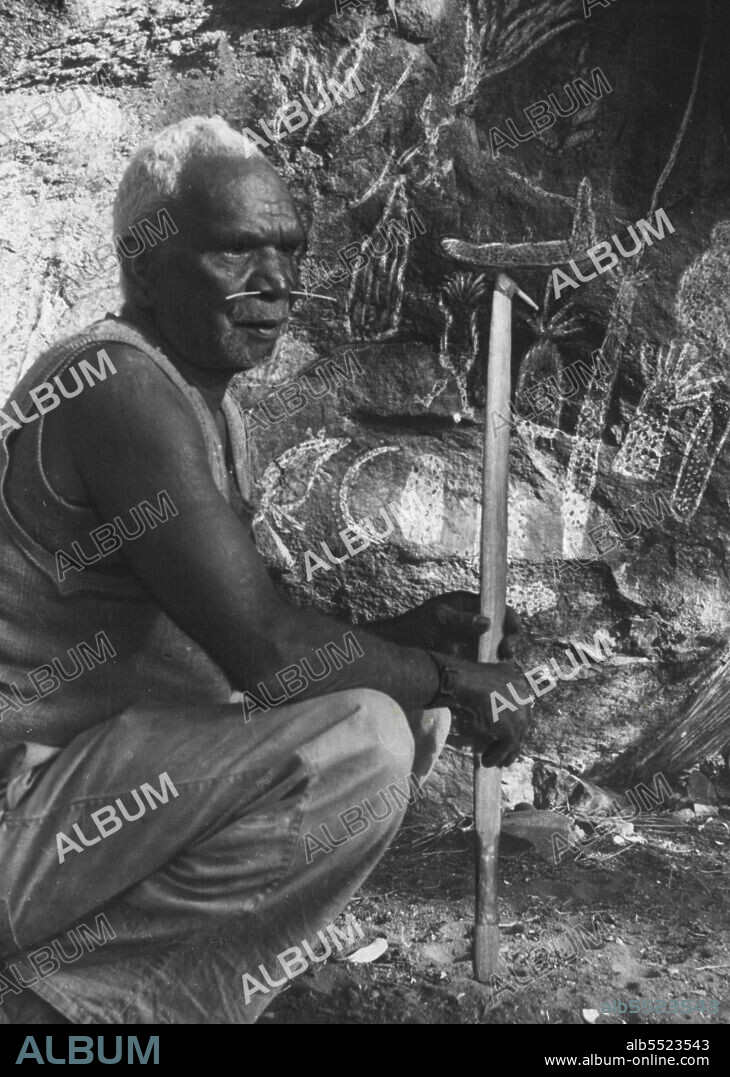 With a fine sense of the value of showmanship, Dudley Bulmer poses for tourists with a twig through his nose which was pierced. September 23, 1953.