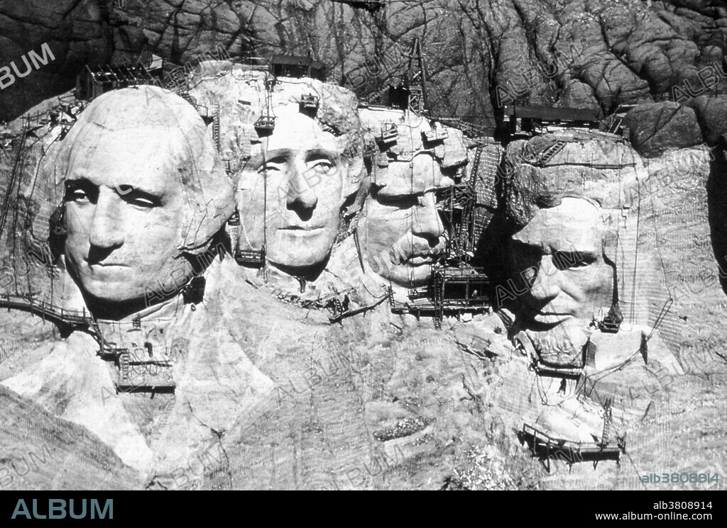 Mount Rushmore National Memorial is a sculpture carved into the granite face of Mount Rushmore near Keystone, South Dakota. Sculpted by Danish-American Gutzon Borglum and his son, Lincoln Borglum, Mount Rushmore features 60 foot sculptures of the heads of four United States presidents: George Washington, Thomas Jefferson, Theodore Roosevelt, and Abraham Lincoln. Construction on the memorial began in 1927, and the presidents' faces were completed between 1934 and 1939. Although the initial concept called for each president to be depicted from head to waist, lack of funding forced construction to end in late October 1941. Mount Rushmore has become an iconic symbol of the United States, and attracts over three million people annually. No photographer credited, circa 1930s.
