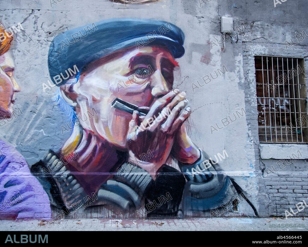 Pintura retrato de abuelo con gorra tocando la armónica, graffiti mural, calle Espronceda, barrio Poblenou; Distrito San Martin, Barcelona en 2016.