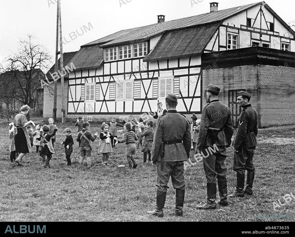 GERMANY around 1940. Orig. caption ... WESTWALL BUNKER WILL BE KINDERGARTEN. 1. In a village of the district Bühl am Rhein, this Westwall bunker disguised as a farmhouse has been added to a new purpose of use. The bunker "Feste Türkenlouis" has become a children's daycare center. The crew quarters of the former bunker crew now serve as living quarters for the local children. The strength of the bunker is good, but without bunker crews, "Feste Türkenlouis" experiences the happy operation of a kindergarten. Photo: AB Text & Bilder / SVT / Code: 5600 Note. For full text see original. Folder: Germany during the war: The children during the war (including schoolchildren) at work etc. V 85: 4 Slideshow Photo report Exterior Preschools Spectators Västvallen Siegfriedlinjen sites: BÜHL; GERMANY PhotoDate: 194? - ?? - ??.