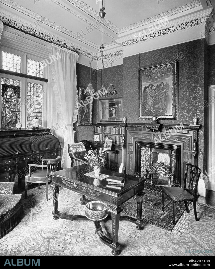 Library, Holmestead, North Mossley Hill Road, Liverpool, Merseyside, 1901. View of the Arts and Crafts interior with Pre-Raphaelite items. The library includes a stained glass image of St Cecilia by Morris & Co. The painting on the chimney breast is 'Gloria in Excelsis' by Evelyn de Morgan and the smaller works are by Rossetti and another de Morgan.