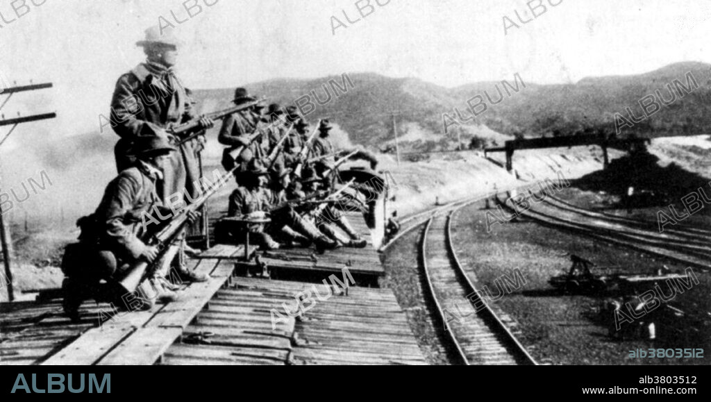 The Ludlow Massacre was an attack by the Colorado National Guard and Colorado Fuel & Iron Company camp guards on a tent colony of 1,200 striking coal miners and their families at Ludlow, Colorado on April 20, 1914. In 1914, when workers at Colorado mine went on strike, company guards fired machine guns and killed several men. More battling followed, during which 2 women and 11 children were killed and John D. Rockefeller Jr., the chief mine owner, was pilloried for what had happened. In retaliation for Ludlow, the miners armed themselves and attacked dozens of mines over the next ten days, destroying property and engaging in several skirmishes with the Colorado National Guard along a 40-mile front. The entire strike would cost between 69 and 199 lives. Congress responded to public outcry by directing the House Committee on Mines and Mining to investigate the incident. Its report, published in 1915, was influential in promoting child labor laws and an eight-hour work day. Photograph originally captioned: The Colorado National Guard preparing their attack.