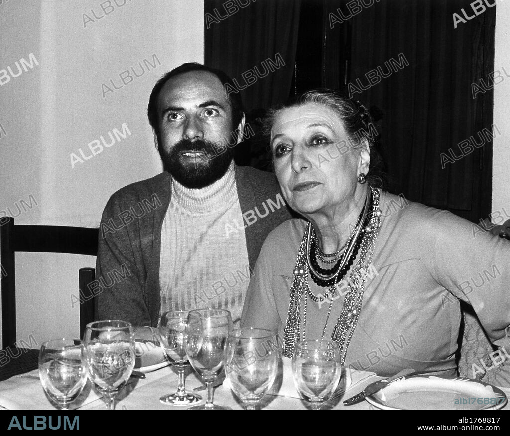 Paola Borboni with her husband Bruno Villar. The Italian actress Paola Borboni and her husband Bruno Villar posing while sitting at table. Italy, 1970s.