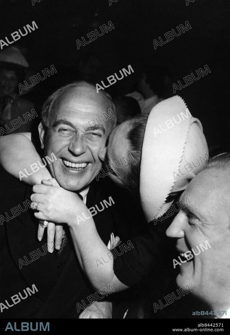 ARKIV STOCKHOLM 19480531.. Lars Egge (t.v.), operettsångare, skådespelare och teaterchef, får en puss av operasångerskan Henriette Guermant medan Erik Larsson tittar på, under Operans solistklubbs vårlunch på Piperska Muren.. Foto: SVT / Kod: 5600. AB Text & Bilder. Mapp: Egge, Lars.