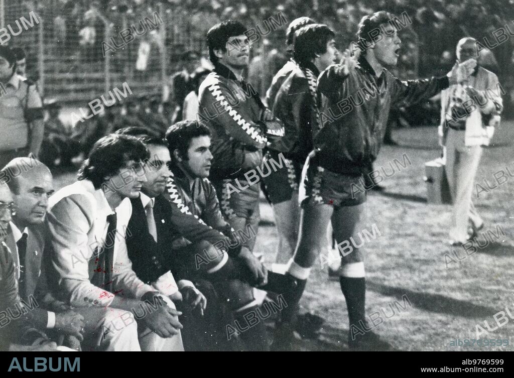 Betis bench during the Benfica-Betis match, the first leg corresponding to the first UEFA Cup Qualifier of the 1982-83 season, the 75th anniversary of Verdiblanco's founding. From left to right, sitting, you see Vicente Montiel, Masseuse; Juan Manuel Mauduit, President; Antal Dunai, Coach; Pedro Buenaventura, Technical Secretary, and the player Antonio Benítez. Standing you can see the players Ramón, corner and Cardeñosa. The match ended with a 2-1 victory for Benfica. In the Vuelta, at the Benito Villamarín stadium, the Portuguese won 1-2. (photo Ruesga bonus.