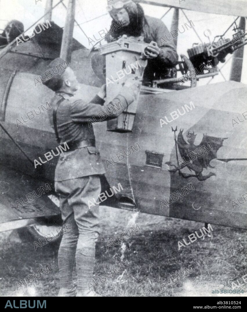 The use of aerial photography rapidly matured during WWI, as aircraft used for reconnaissance purposes were outfitted with cameras to record enemy movements and defenses. The Royal Flying Corps recon pilots began to use cameras for recording their observations in 1914 and by the Battle of Neuve Chapelle in 1915, the entire system of German trenches was being photographed. The first purpose-built and practical aerial camera was invented by Captain John Moore-Brabazon in 1915. The camera was inserted into the floor of the aircraft and could be triggered by the pilot at intervals. By the end of the war, aerial cameras had dramatically increased in size and focal power and were used increasingly frequently as they proved their pivotal military worth; by 1918 both sides were photographing the entire front twice a day and had taken over half a million photos since the beginning of the conflict. Caption: "Lieutenant J.H. Snyder receiving a French 1824 size camera that could photograph from 25,000 feet, August 1918.".