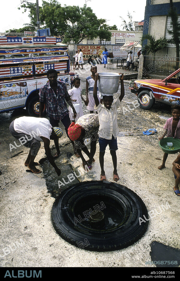 Editorial use only . A street scene in downtown Port-au-Prince where Haitians bathe and collect water for home use. Most water in Port-au-Prince has to be carried as few homes have running water or flowing potable water. May 18, 1994.