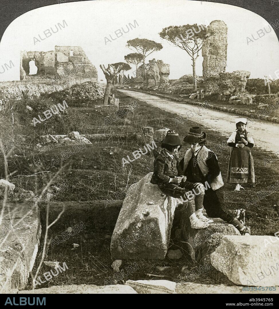 Tombs and children in traditional dress, Appian Way, Rome, Italy. The Appian Way (Via Appia) was a road built by the Romans that connected Rome with Brindisi on the Apulian coast. Its primary purpose was to enable the rapid movement of troops. Stereoscopic card detail.