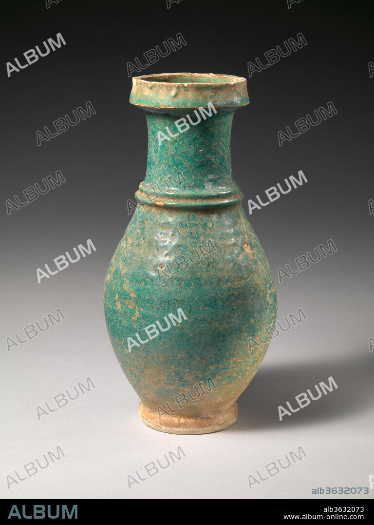 Jar. Culture: Sasanian. Dimensions: 13.5 in. (34.29 cm). Date: ca. 6th-7th century A.D..
A green-blue glaze covers the jar's exterior and its interior is coated with bitumen. Two concentric bands encircle the neck. Ceramics glazed in green, blue-green, and yellow were produced in Mesopotamia and southwest Iran during the Sasanian period. The dating of Sasanian pottery is complicated due to the lack of examples from controlled excavations at Sasanian sites, however, in contrast to ceramics produced during the Islamic period, glazes cover Sasanian vessels uniformly and additional designs are not defined through the use of differently colored glazes.