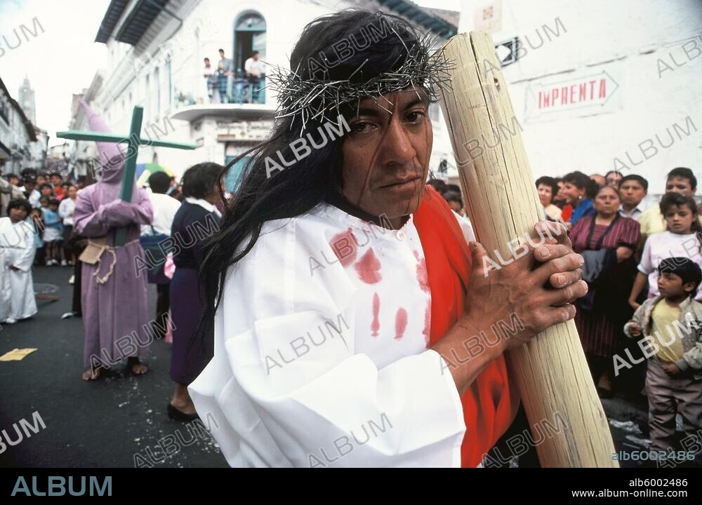 Religion / Passion Play. Quito (Pichincha province, Ecuador): Good Friday Procession through the old town of Quito. Believers act out the carrying of the cross.-Procession: carrying the cross. In the background: members of brotherhoods wearing cucuruchos (hoods).-Photo, 1988.