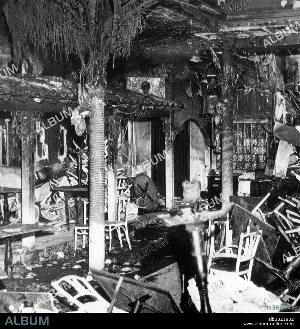 On November 28th 1942, a deadly fire occurred at the Cocoanut Grove Nightclub in Boston, Massachusetts, where 492 people perished. The club had a licensed capacity of 500 people, and on the night of the fire there were about 1000 people in the building. At about 10:15PM that evening, a busboy had been ordered to fix a light bulb, but needed to light a match to locate the light socket. Several patrons saw a flicker of a flame in the palm tree of the ceiling decorations. As other furnishings ignited, a fireball of flame and toxic gas raced across the room toward the stairs. The fireball traveled up the stairs and burst into the Foyer area, where coatrooms, restrooms and the main entrance were located. After a small number of people exited, the revolving door became jammed due to the crush of panicked patrons. Observers outside could only watch in horror as relatives and friends were crushed by the weight of the crowd surging against the jammed door. Burnt out interior of the Cocoanut Grove Nightclub.