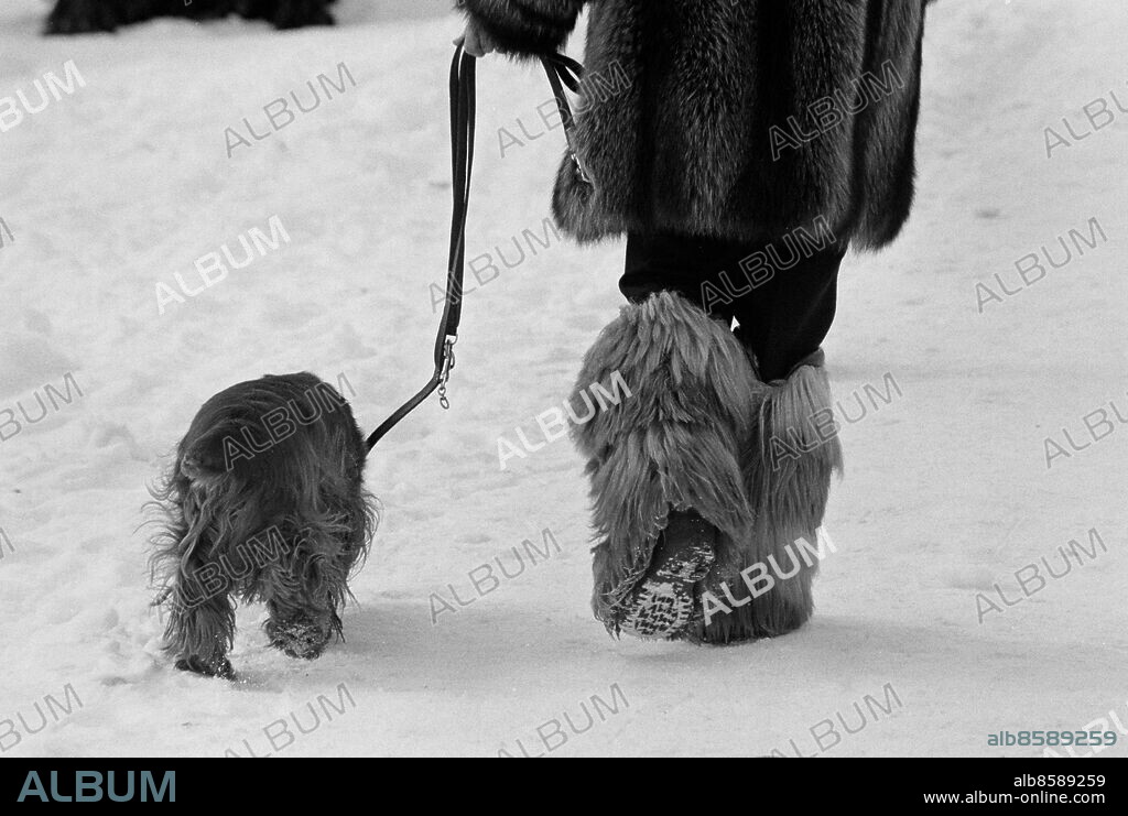 1975 - Sådan matte sådan hund. En kvinna med lurviga vinterstövlar på promenad med sin lurviga hund. Foto: Torbjörn Andersson / XP / SCANPIX / Kod 4. ** AFTONBLADET OUT **.
